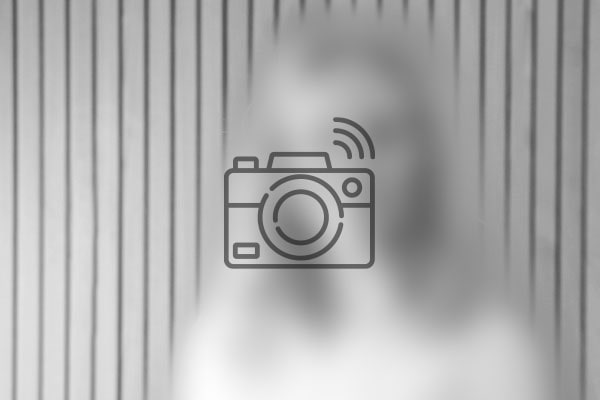 Billede af et illustreret kamera foran et sløret portræt af en person
