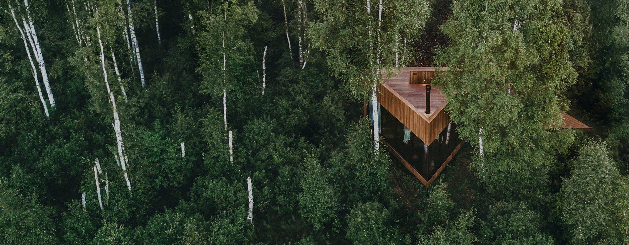 Maidla Resort, en triangulär byggnad i skogen, byggd med Thermo Ask-trä och i-CLiPS-systemet, smälter sömlöst in i naturen.